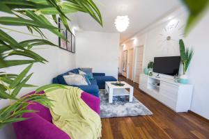 a living room with a blue couch and a tv at Apartment Tina in Split