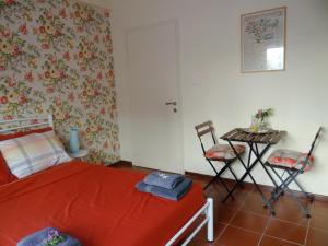 a bedroom with a red bed and a table and chairs at Floral Tribute Studio in Kavála +29 photos
