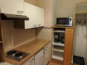 una piccola cucina con piano cottura e forno a microonde di Apartment Schilcher a St. Wolfgang