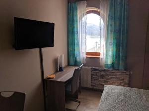 Zimmer mit einem Schreibtisch, einem Monitor und einem Fenster in der Unterkunft Apartment Schilcher in St. Wolfgang