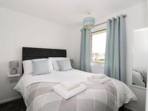 a bedroom with a bed with two towels on it at Sunbeach Chalets in Great Yarmouth