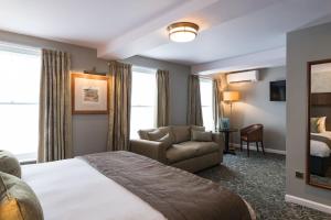 een hotelkamer met een bed en een stoel bij The King's Head Hotel - JD Wetherspoon in Monmouth