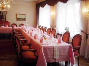 a long table in a room with pink tables and chairs at Hotel Alte Post in Wangen im Allgäu
