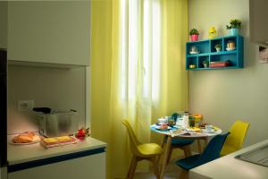 a kitchen with a table and chairs and a table and a small table with yellow at Naplesuite in Naples