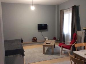 ein Wohnzimmer mit einem Tisch und einem TV an der Wand in der Unterkunft Renovated apartment in Athen