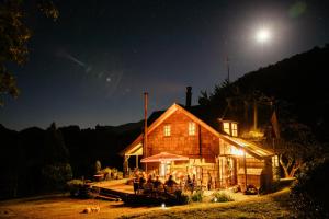 a group of people sitting outside of a house at night at Barraco Lodge in Puelo