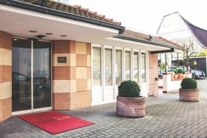 ein Gebäude mit einer roten Matte davor in der Unterkunft Hotel Löwen-Seckenheim in Mannheim