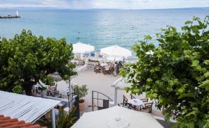 a view of a beach with tables and umbrellas at Xenios Hotel in Pefkochori