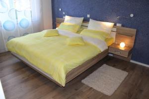 a bedroom with a large bed with yellow sheets and pillows at Ferienwohnung Loreley in Lierschied