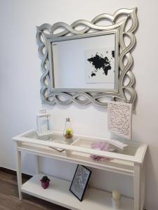 un espejo sobre un escritorio blanco con un estante en Casa de Campo Cruz de Pedra, en Portomarín
