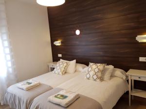 um quarto com 2 camas e toalhas em Casa de Campo Cruz de Pedra em Portomarín