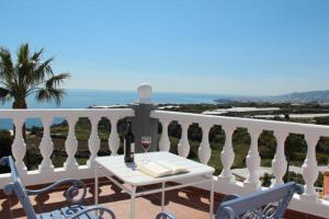 a white balcony with a table and a glass of wine at Apartamentos Maro VG in Maro