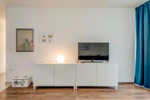 Una habitación blanca con un televisor en una pared blanca. en Apartment Zara, en Split