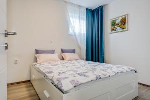 Un dormitorio pequeño con una cama con cortinas azules. en Apartment Zara, en Split