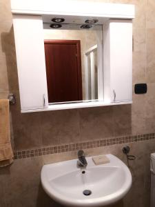 a bathroom with a white sink and a mirror at Beach Apartment in Rafailovici +23 photos