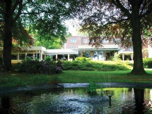 een eend in het water voor een gebouw bij Fletcher Hotel-Restaurant Paasberg in Lochem