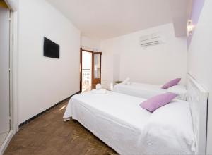 a bedroom with a white bed and white walls at Hostal Alicante in San Antonio