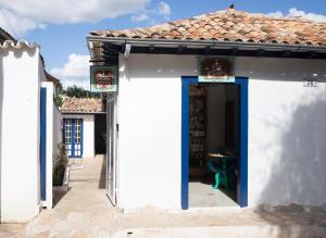 a white house with blue doors and a tile roof at Pousada Sinhá Vilaça in Tiradentes