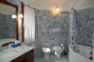a bathroom with a toilet and a tub and a sink at Fonte Del Ulivo Codice Iun F3138 EX Antica Fonte3 in La Maddalena