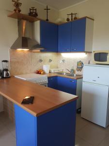 uma cozinha com armários azuis e um frigorífico branco em Christina´s Beachside Apartment em Rio