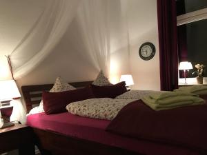 1 dormitorio con 1 cama, 2 lámparas y reloj en Leezdorfer Hof en Leezdorf
