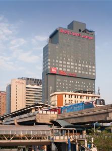 a train on a bridge in front of a building at Mercure Bangkok Siam in Bangkok