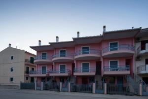 a pink building with balconies on the side of it at K Houses I4 in Lefkada