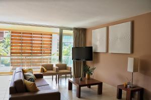 uma sala de estar com um sofá e uma televisão em Herdade dos Salgados Beach apartment em Albufeira