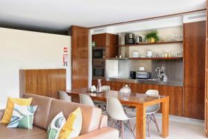 アルブフェイラにあるHerdade dos Salgados Beach apartmentのダイニングルーム、キッチン(テーブル、椅子付)