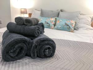 a pile of towels sitting on top of a bed at Garden Apartment in Grange Over Sands