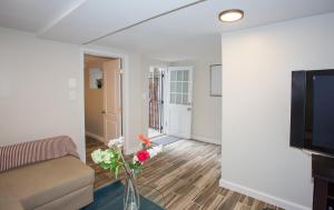 een woonkamer met een bank en bloemen in een vaas bij 2 Full Bedrooms Basement Apt; 3-Min Walk To Petworth Metro; in Washington