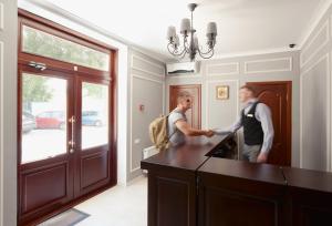 two men are standing in a kitchen at Geneva Resort Hotel in Odesa