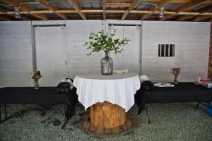 een tafel met een vaas met bloemen op een houten stronk bij Valle Crucis Farm in Valle Crucis