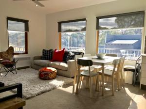 a living room with a table and a couch at Apres in Dinner Plain