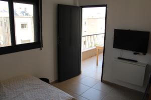 a bedroom with a bed and a flat screen tv at Apartments With Sea View in Haifa