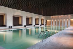 una piscina en un hotel con sillas en el agua en Hyatt Regency Wuhan Optics Valley en Wuhan