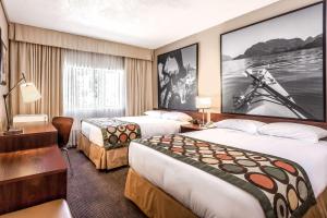 a hotel room with two beds and a large screen at Super 8 by Wyndham Duncan in Duncan