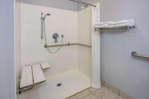 a bathroom with a shower with a bench in it at Super 8 by Wyndham Sweet Springs in Sweet Springs