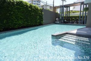a swimming pool with blue water in a building at Bann Imm Aem Condo No.376 in Hua Hin