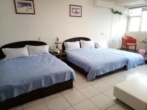 頭城的住宿－大溪漁港姸海地帶民宿，一间卧室配有两张床和红色椅子