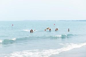 a group of people swimming in the ocean at Hon Rom Central Beach Resort in Mui Ne