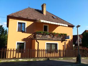 a yellow house with a fence and flower boxes at Penzion Zavodsky in Český Krumlov