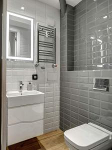 a bathroom with a sink and a toilet and a mirror at Apartment Rotonda in Sofia