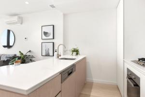 a kitchen with white countertops and a sink at Luxuria Apartments - EQ Tower in Melbourne