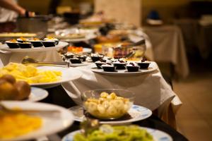 una línea de buffet con platos de comida en los platos en Hotel Tolin, en Ronco allʼAdige