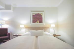1 dormitorio con 2 camas blancas y 2 lámparas en Best Western Hotel Hamburg International, en Hamburgo