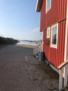 a red building next to a body of water at Seaview Cottage Solvik - Kungshamn in Kungshamn