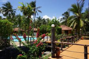 a resort with a swimming pool and palm trees at Puetz Travels Beach Resort in Wayikkal