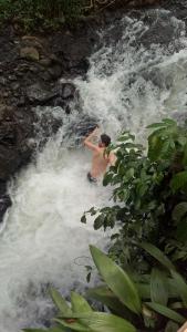 een man surft in een rivier in het water bij Mi Casa - The gem of Ijen in Banyuwangi