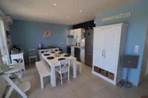 una cucina con tavolo e sedie e una cucina con pareti blu di résidence Monte leone a Bonifacio